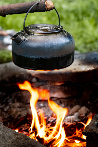 istock Making tea over an open fire in the forest. The kettle is hanging on a stick on the fire. 2167763603