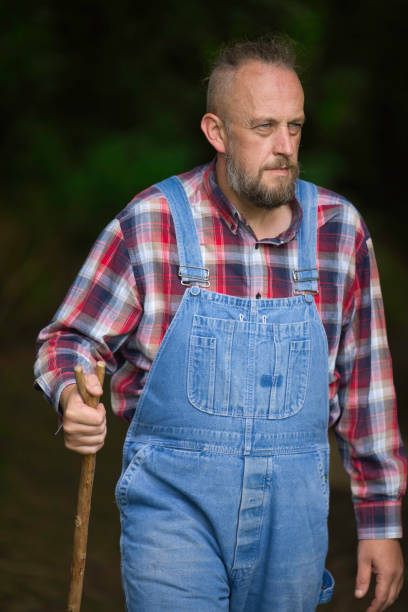 Casually dressed man wearing denim and a checked shirt.