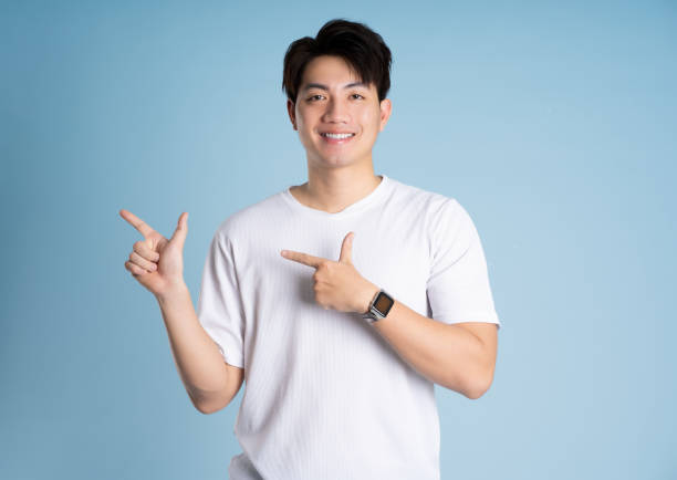 istock Portrait of Asian guy posing on blue background 2167764434