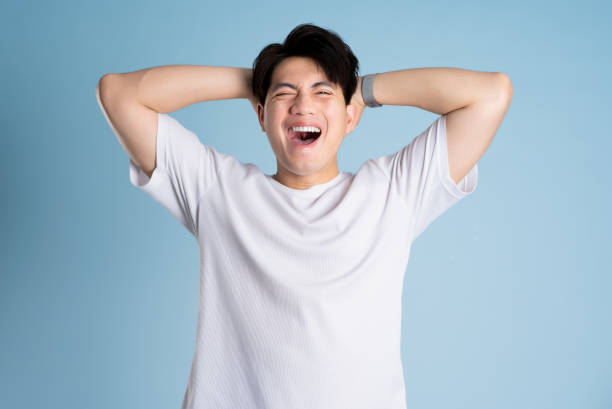 istock Portrait of Asian guy posing on blue background 2167764451