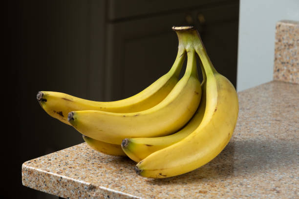 istock Yellow Bananas in a Bunch on Brown Granite Counter 2167767187