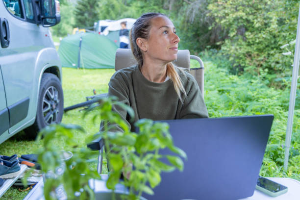 istock Smiling Woman Working Remotely at a Campsite 2167768313