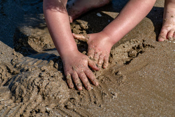 istock Child at sea playing with shells, sand and water 2167771169