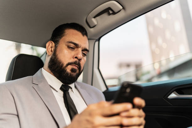 istock Businessman using mobile phone in a cab 2167771656