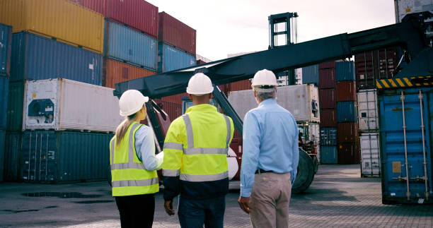 istock Back, container and supervisor talking to staff at commercial dock for supply chain logistics. Conversation, management and shipping with industrial team of people at harbor for export or import 2167775966