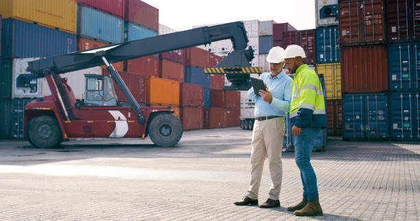 istock Logistics, man and supervisor in container yard for tablet inventory, stock and supply chain or freight. Discussion, inspection and quality control in industry, shipping in trade for commerce export 2167775993