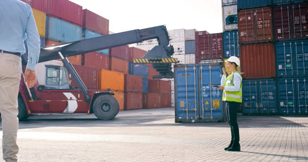 istock Radio, containers and logistics worker by crane for heavy loading with global product trade at freight port. Intercom, supply chain and female distribution planner with cargo stock for shipping. 2167776000