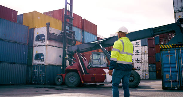 istock Back, man and shipping with container outdoor for cargo crane, logistics construction or delivery safety on forklift. Worker, truck directions and help export, transport service and distribution dock 2167776018