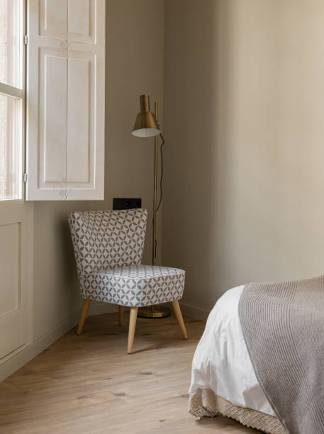 istock Cozy bedroom corner with patterned chair, modern floor lamp, and neutral tones 2167779347