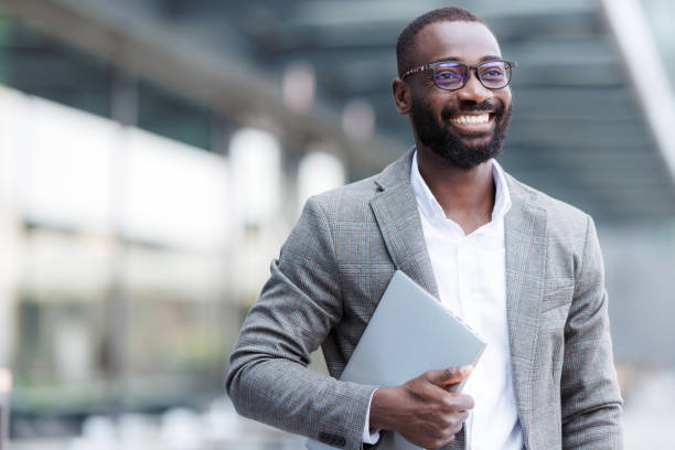 istock Confident businessman holding laptop outdoors in urban setting 2167779382