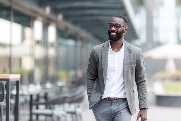 istock Confident man in business suit walking outdoors with a smile 2167779412