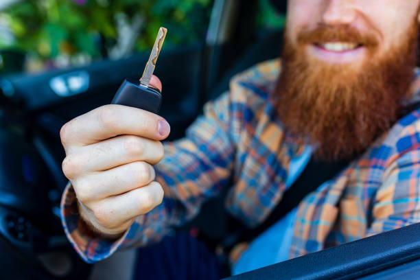handsome redhaired ginger man with long beard going on trip during summer vacation on new car.