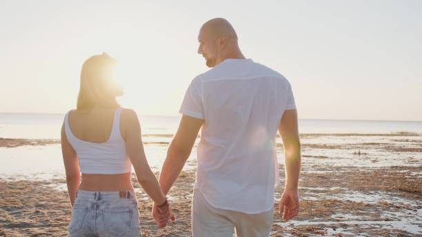 istock Happy young couple standing on the sea coast while hugging 2167780876