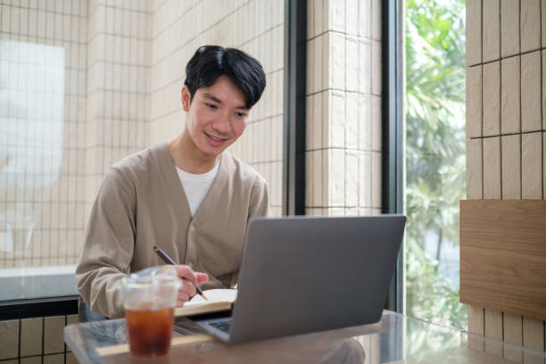 istock A young man is seen working and writing in a contemporary cafe. 2167782023