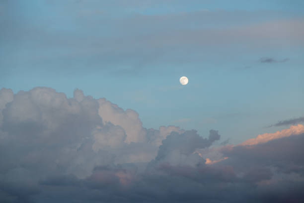 istock Horizontal shot cumulus clouds float across the evening sky with a full moon on a warm spring evening. Concept summer mood and good weather. Copyspace 2167788909
