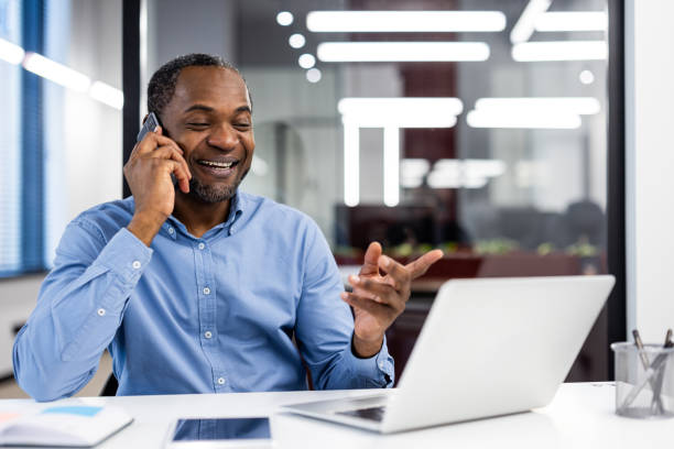 istock Businessman having a phone call and using laptop in modern office 2167790224