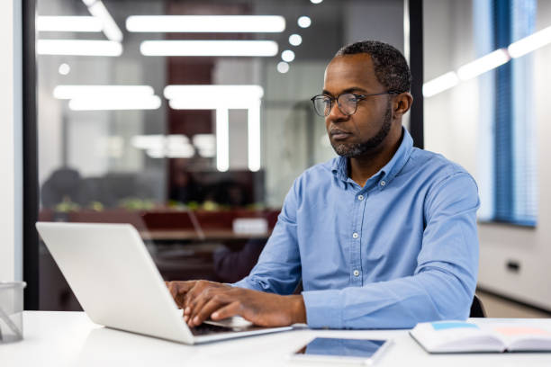 istock Focused african american office worker at workplace with laptop in office 2167791872