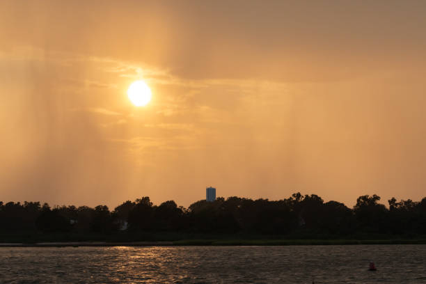 A thunderstorm can be seen over Staten Island from Keyport during golden hour