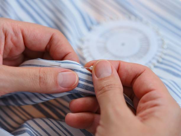 istock Woman hands using a sewing push pin on the clothes. Close-up 2167793780