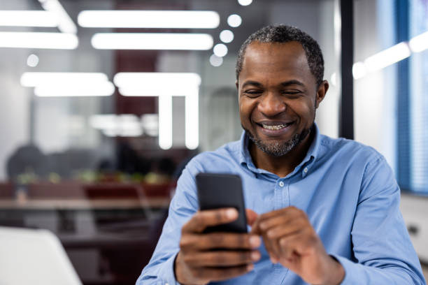 istock Happy african american office worker using smartphone in modern office 2167794440