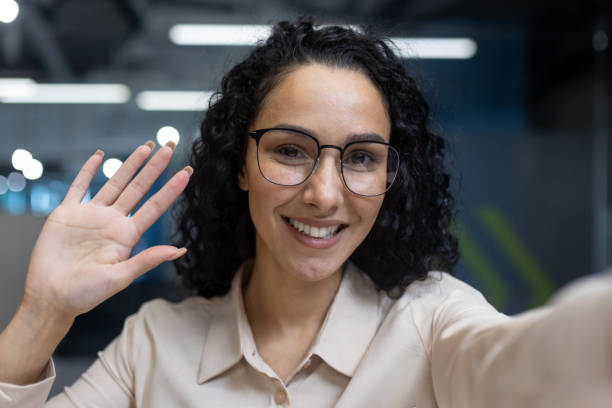 istock Friendly female office worker waving during video call meeting in modern workspace 2167795969