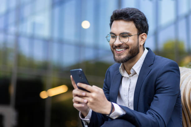 istock Happy businessman using smartphone outside office building 2167798974
