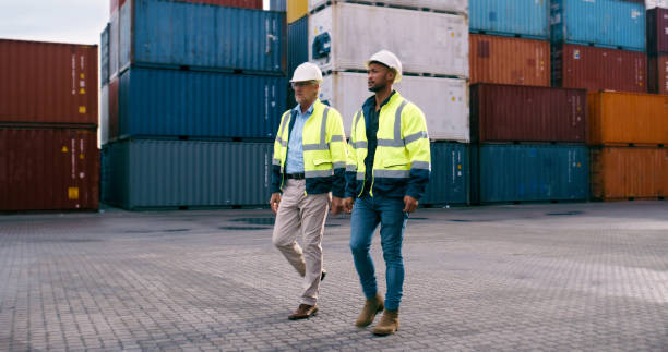 istock Walking, containers and men with export, stock and industry with import, logistic service and commerce. Business people, employees and coworkers with international trade, shipping and global delivery 2167799297