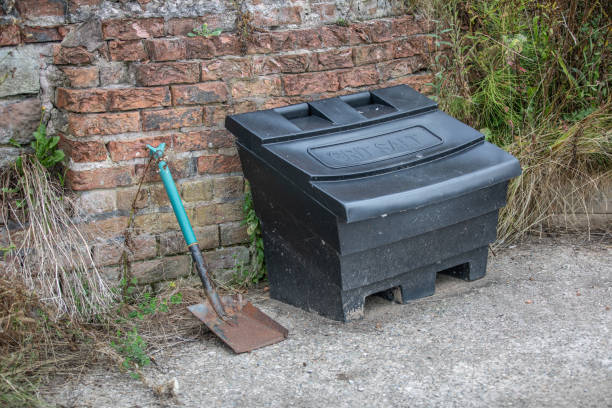 istock Grit salt stored in a large green plastic container with shovel laid alongside the container. 2167800334