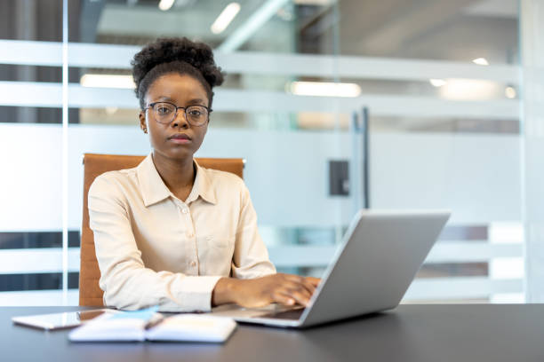 istock Confident businesswoman working on a laptop in a modern office setting 2167800497
