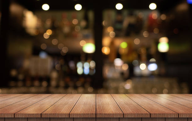 istock Empty wooden table top with lights bokeh on blur restaurant background. 2167800844