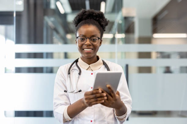 istock Smiling doctor using digital tablet in modern medical office 2167801838