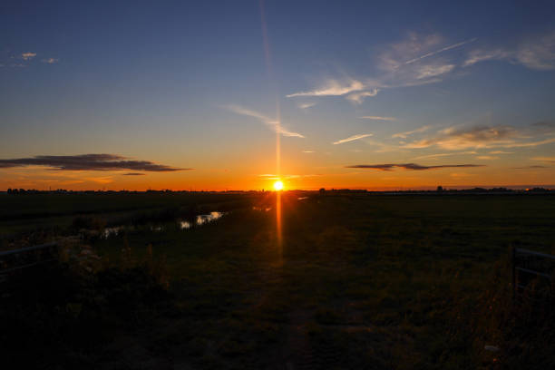Sunset over the meadows of the Zuidplaspolder at the watering canal in the Netherlands