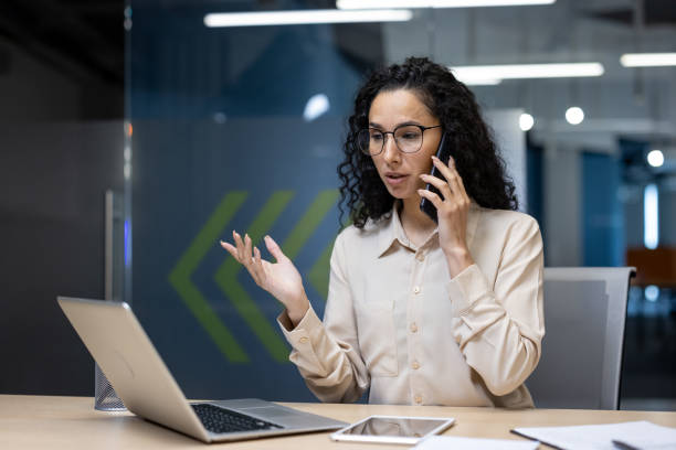 istock Professional woman on phone call while working at her laptop in modern office 2167802614