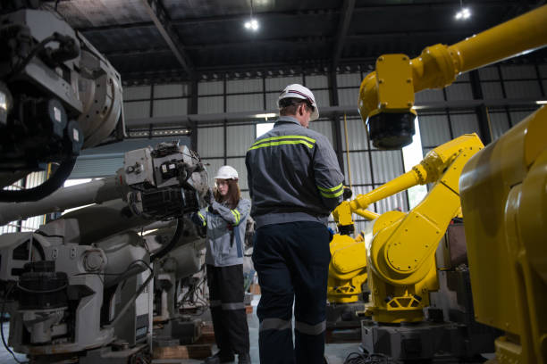 istock Engineer standing by robotic arm and operating machine in industry factory 2167802959