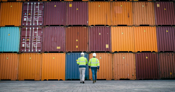 istock Collaboration, container and inspection with men walking at shipping yard for logistics or supply chain. Inventory, stock and storage on cargo background for delivery, export or import from back 2167803110