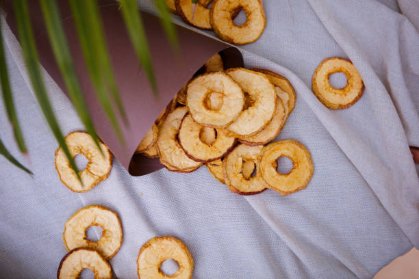 Organic apple cinnamon chips (slices) over white background with copy space - healthy vegan vegetarian fruit snack or ingredient for baking, cooking