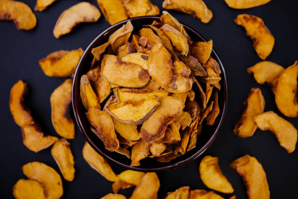 Homemade dried apples with cinnamon, apple chips on a wooden background. Delicious healthy snack.