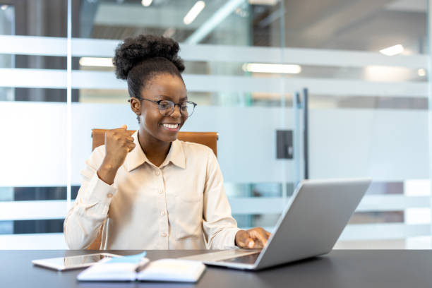 istock Smiling professional woman working on laptop in modern office environment 2167804696