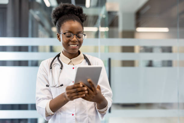 istock Smiling doctor using a tablet in a modern medical office 2167805329