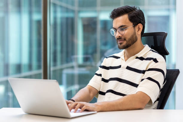 istock Young professional working on laptop in modern office environment 2167805788