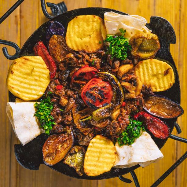 istock Saj with meat and grilled vegetables served on a wooden table 2167806018