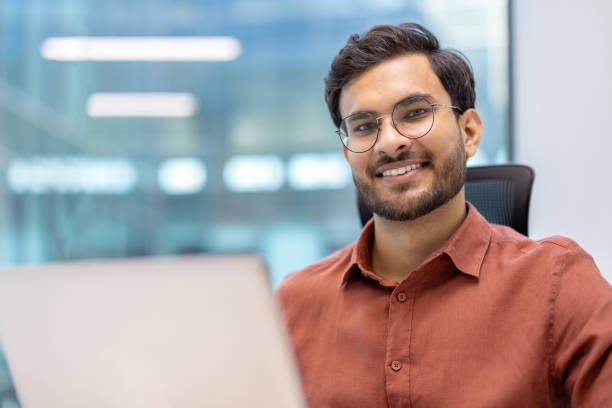 istock Confident young professional smiling at desk in modern office setting 2167806033