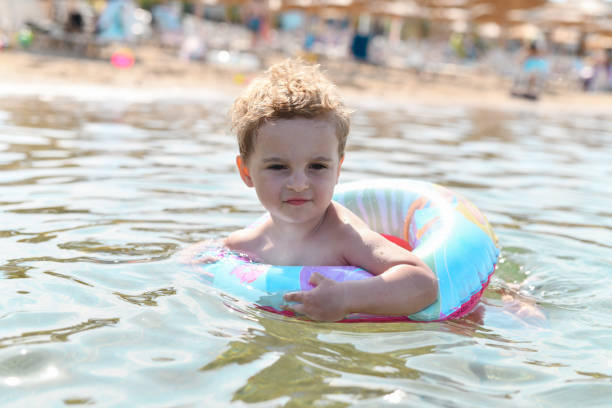 istock Toddler Enjoying Summer Fun In Lake With Inflatable Ring 2167808881
