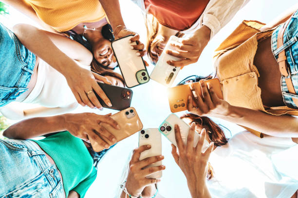 istock Group of young people using smart mobile phone device outside - Trendy technology concept with guys and girls playing video games app on smartphone - Bright colorful filter 2167810320