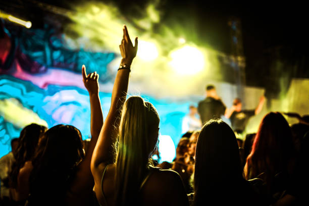 People Raising Arms And Dancing During DJ Party