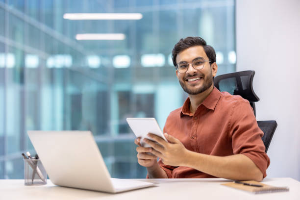 istock Young professional man using tablet and laptop in modern office environment 2167814238