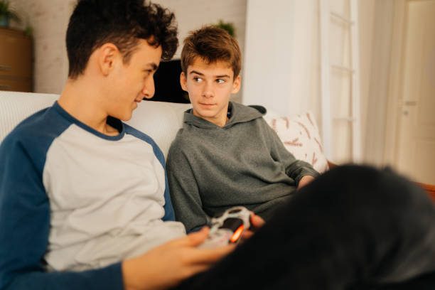 istock Boys having fun playing video games with joystick at home 2167815914