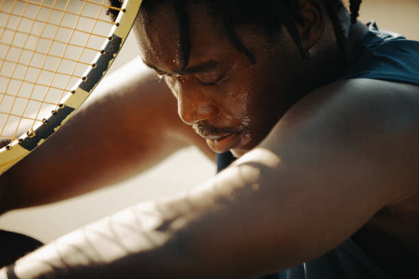 istock Man resting with tennis racket, looking sad in sunlight after a challenging game 2167817054