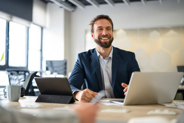 istock Cheerful young business manager verifying financial information on digital tablet inside his office 2167817709