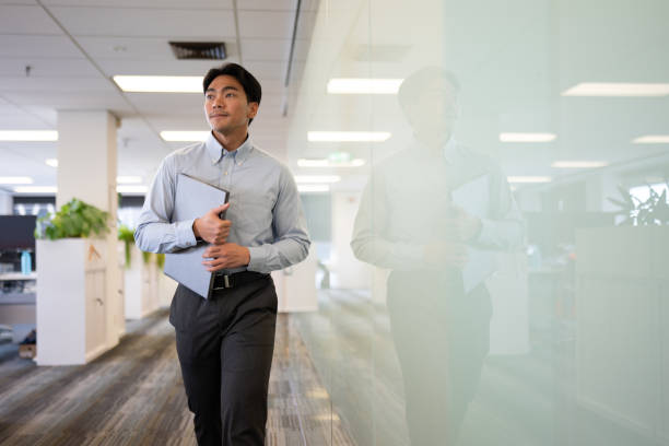 Confident Young Male Walking with Laptop
